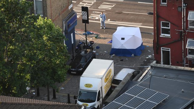 A police forensics officer examines the scene at Finsbury Park, where one person was killed and eight were injured in a van attack.