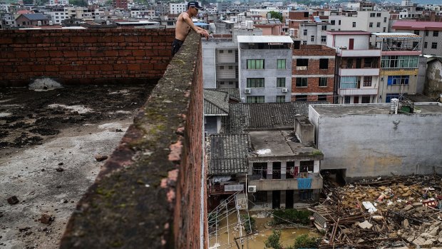 A man looks down at the damage in Fuijan, China. 