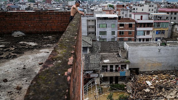 A man looks down at the damage in Fuijan, China. 