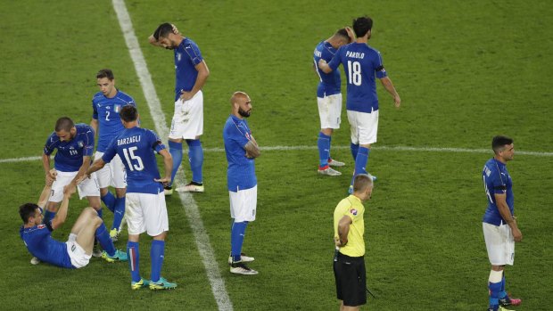 Devastated: Italian players after the decisive penalty.