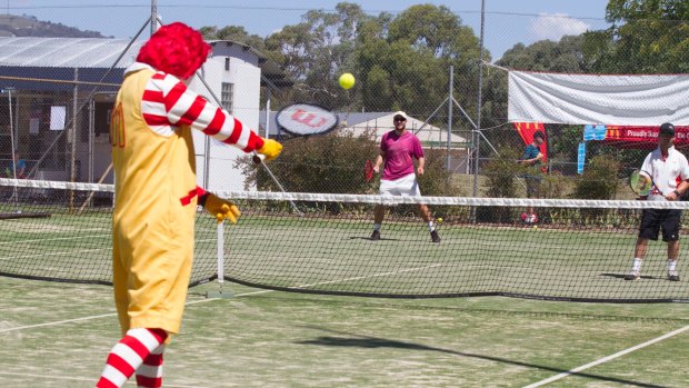 Ronald McDonald, Nick Francis and Robert Jamieson have a hit at last year's 24-challenge at the Pines Tennis Club in Chisholm for Ronald McDonald House Canberra.