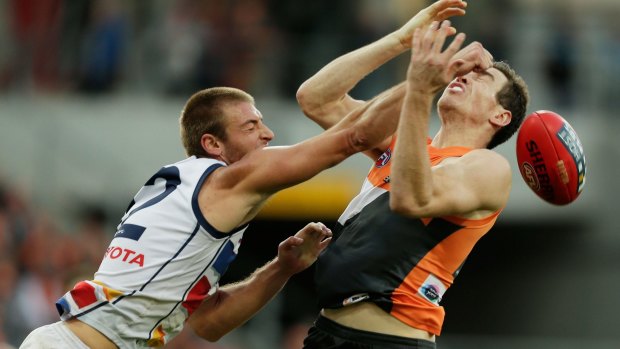 Jeremy Cameron of the Giants and Daniel Talia of the Crows compete for the ball.