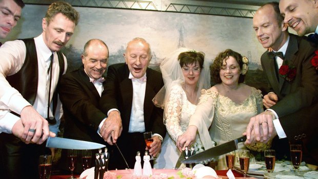Peter Lemke, Frank Wittebrood, Ton Jansen, Louis Rogmans, Helene Faasen, Anne-Marie Thus, Dolf Pasker and Geert Kasteel (L-R) cut the cake after their wedding ceremony in the town hall of Amsterdam, April 1, 2001.  The two lesbian brides and six gay grooms became the world's first homosexuals to wed legally, minutes after a Dutch law allowing same-sex matrimony came into effect.   