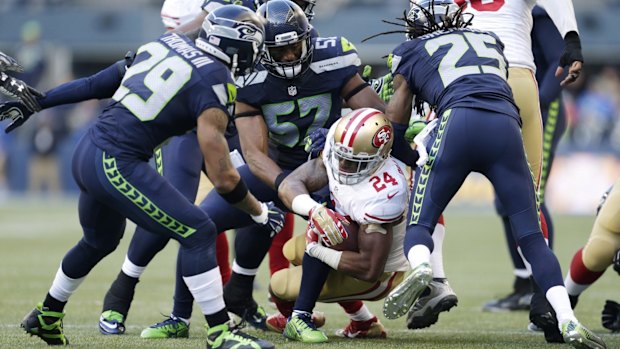 Brought down: San Francisco 49ers running back Shaun Draughn is tackled by the Seattle defence.