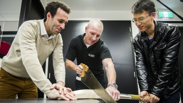 Australian wicketkeeper Brad Haddin meets scientists from the ANU, Dr Mohammad Saadatfar (left) and Jin Tao, who are doing technological research into cricket bats.