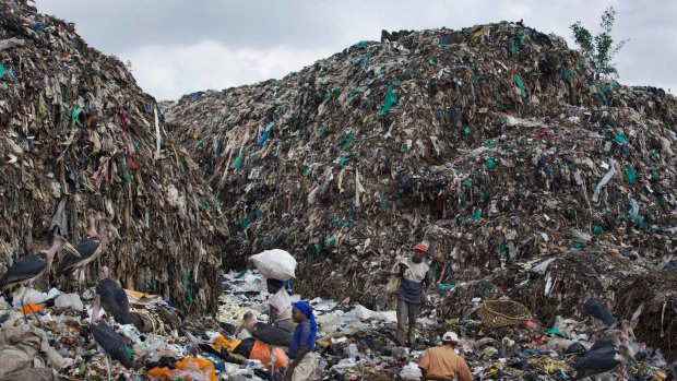 Men and women scavenge for recyclable materials amidst mountains of garbage and plastic bags at the dump in the Dandora slum of Nairobi, Kenya. 