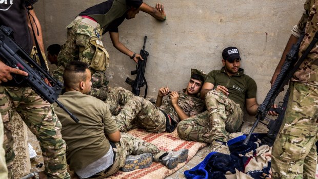 Iraqi government fighters rest between operations in the Nazal district of Fallujah this week. 