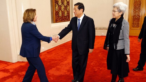 US House Minority Leader Nancy Pelosi, left, shakes hands with Zhang Ping, vice-chairman of China's National People's Congress, in Beijing. At right is Fu Ying.