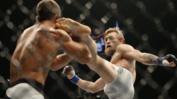 Conor McGregor, right, kicks Chad Mendes during their interim featherweight title mixed martial arts bout at UFC 189 Saturday, July 11, 2015, in Las Vegas. (AP Photo/John Locher)