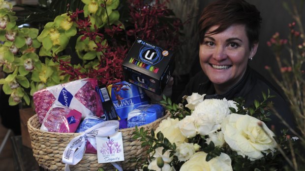 Moxom and Whitney florist on Lonsdale Street, Braddon. Co- owner, Belinda Whitney with a donation basket full of women's sanitary products, donated by customers for the Share the Dignity campaign.