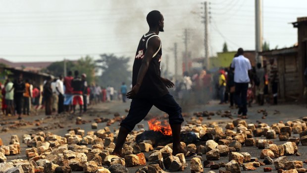 A man walks through paving stones and a tyre fire during protests against the governing party  in Bujumbura, Burundi, on June 26, 2015. 
