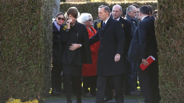 Prime Minister Tony Abbott and wife Margie depart after placing a wreath at the national MH17 memorial on Friday.