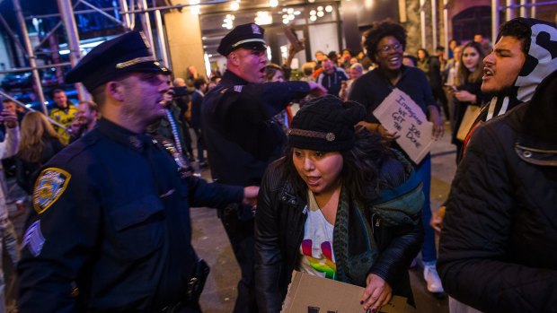 Police remove protesters from the streets after they shouted slogans at Vice President-elect Mike Pence while he was leaving a performance of Hamilton.