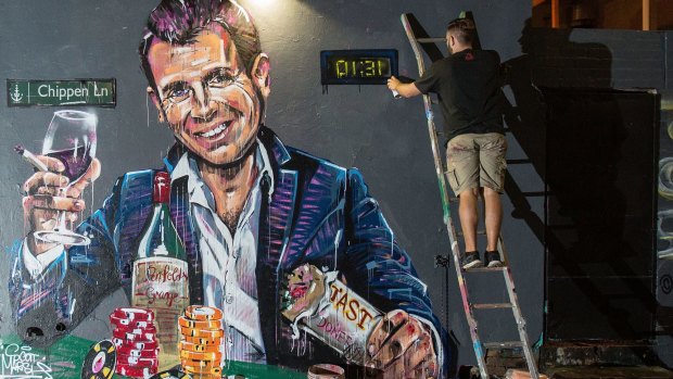 Artist Scott Marsh paints a mural of NSW Premier Mike Baird holding a kebab and glass of wine surrounded by poker chips.