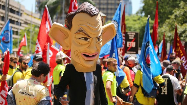 A caricature of Prime Minister Tony Abbott walks among the unionists.