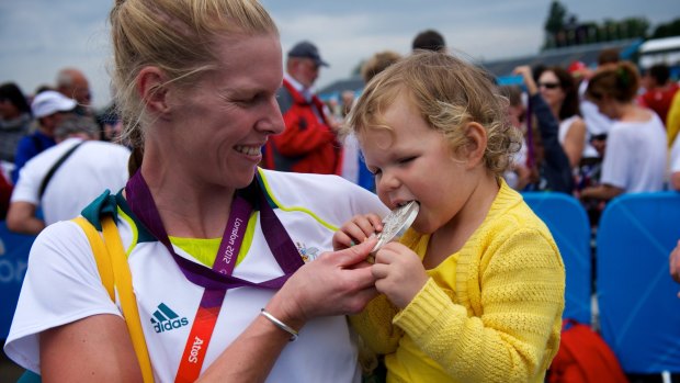 Sarah Tait shows off her medal to daughter Leila after winning silver at Eton Dorney.