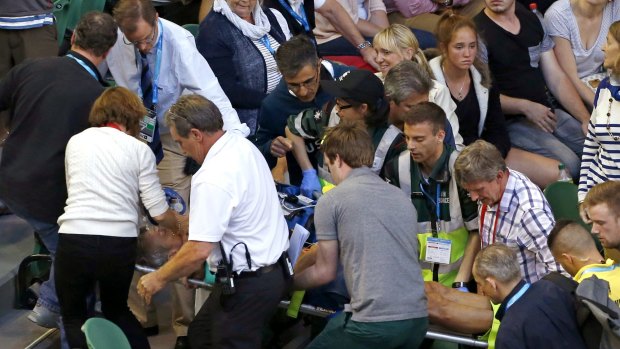 Ana Ivanovic's coach Nigel Sears is carried on a stretcher from Rod Laver Arena.