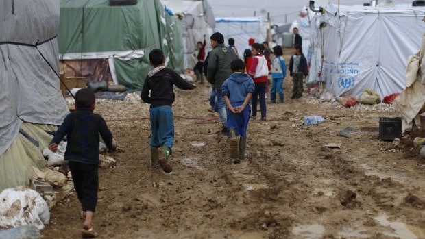 Syrian refugee children walk in mud after heavy rain in January at a refugee camp in east Lebanon.