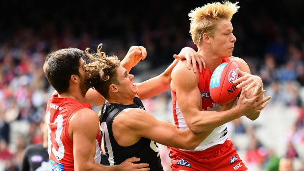 Isaac Heeney takes a mark in front of Blue Charlie Curnow.
