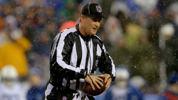 Umpire Carl Paganelli with one of the footballs during the Patriots and Colts clash.