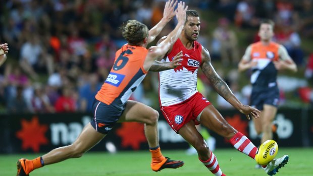 Lachie Whitfield of the Giants tries to charge down a kick from Lance Franklin.