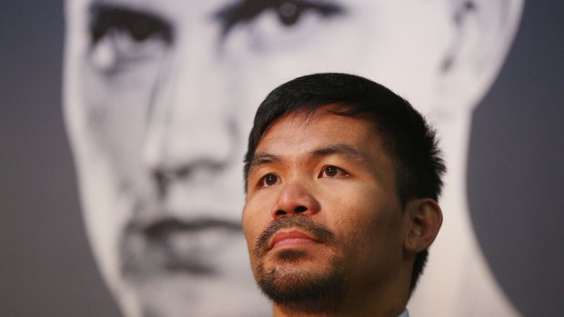 He's behind you: Manny Pacquiao speaks to the media as a picture of Jeff Horn looms over him.