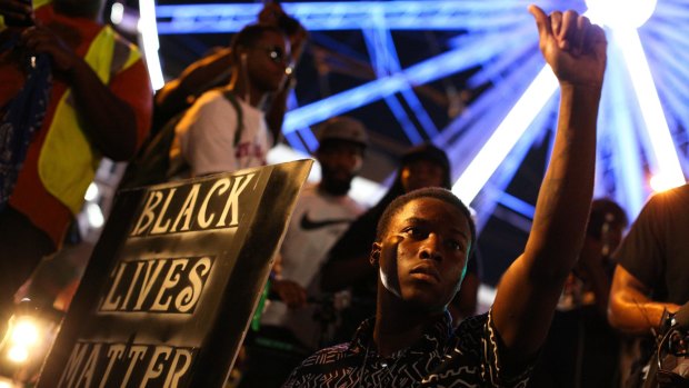 A demonstrator holds a sign during a protest in Atlanta in response to the police shooting deaths of Terence Crutcher in Tulsa and Keith Lamont Scott in Charlotte.