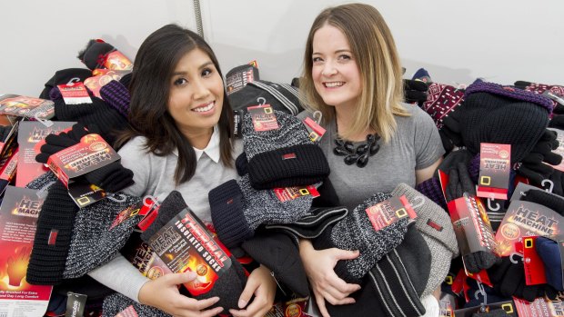 Canberra mothers Soudalay Thammavongsa, left, and Emma Madsen with hundreds of thermal socks for the homeless.