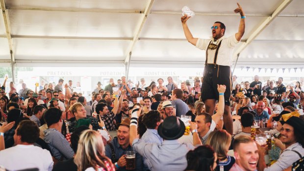 Dean Schmahl celebrates skolling a beer at Oktoberfest at the Queanbyean showground.