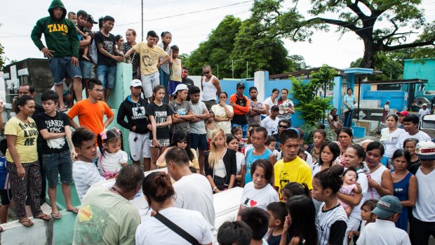 Relatives mourn as the coffin of an alleged thief and drug peddler and victim of an extrajudicial killing is laid to rest on August 21 in Manila.