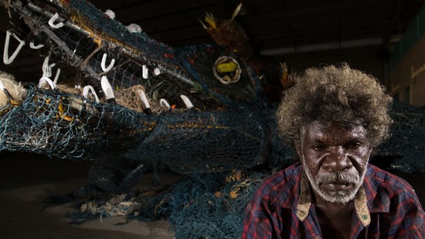 Eric Norman with the almost eight-metre ghost net sculpture of a crocodile he created with other Pormpuraaw artists for the Cairns Indigenous Art Fair.