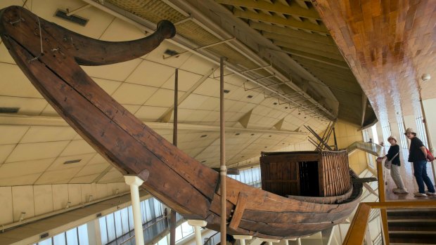 Tourists inspect King Khufu's first boat, which is displayed at the boat museum at the pyramids site in Giza.