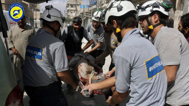 Rescue workers carry an injured man at the site of air strikes in the al-Sakhour neighbourhood of Aleppo.