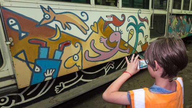 Henry Larwill takes a photo of Michael Leunig's art tram, also from 1986, now stored at the Newport Rail Yards.