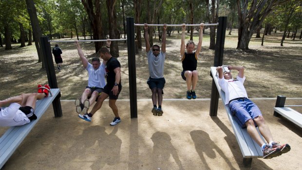 Health and fitness guru Lee Campbell takes a workout session for Territory and Municipal Services staff at one of the ACT's outdoor fitness stations run.