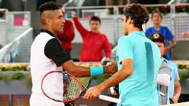Nick Kyrgios shakes hands at the net after his three-set victory against Roger Federer in Madrid.