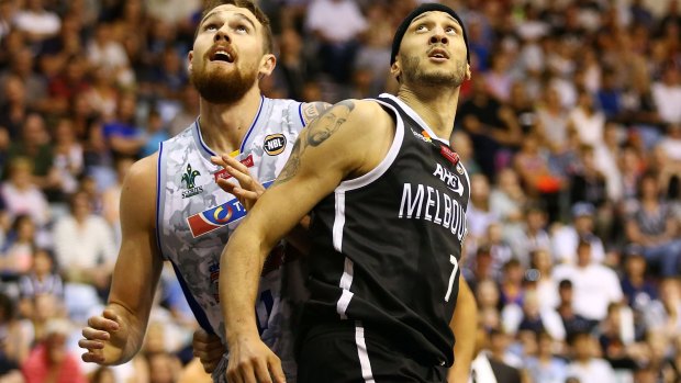 Josh Boone of Melbourne United (right) tangles with Adelaide's Eric Jacobsen.