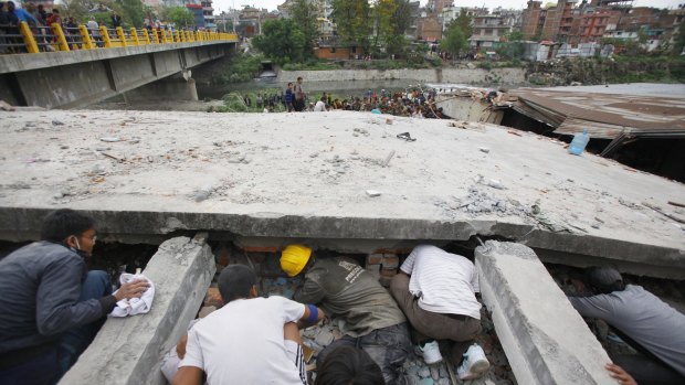 Rescuers look for victims under a collapsed building in Kathmandu.