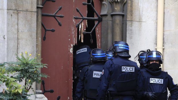 French police officers storm a church after a raid in Paris suburb Saint Denis.  