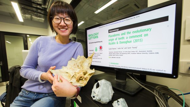 ANU PhD student Yuzhi Hu with a 3D model of a fish fossil created after completing a CT scan on the fossil found near Lake Burrinjuck