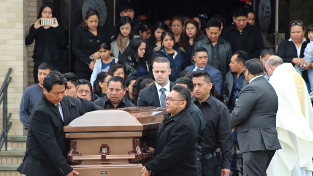 The coffin of 16-year-old Justin Llivicura,  is carried from St Joseph the Worker Church in Suffolk County, New York State, in April. Llivicura was one of four young men found slain in a suspected MS-13 gang killing.