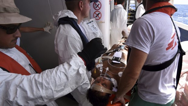 An unconscious refugee is evacuated from the MY Phoenix by MSF and Migrant Offshore Aid Station crew to an Italian warship. 