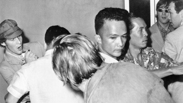 The Beatles, John Lennon (right, dark glasses) and Paul McCartney (centre, back to camera), are jostled at Manila Airport.