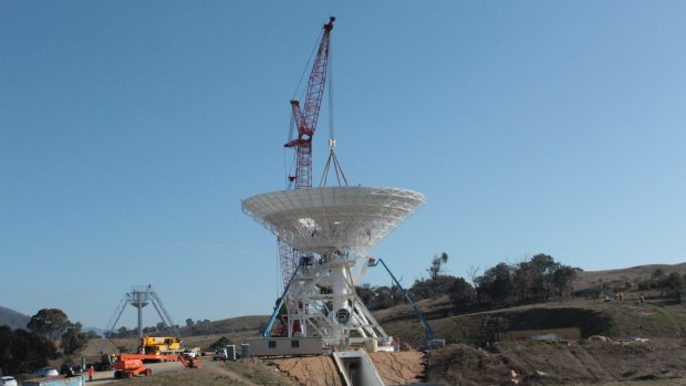 The Deep Space Station 36 antenna dish is lifted into place on Thursday.