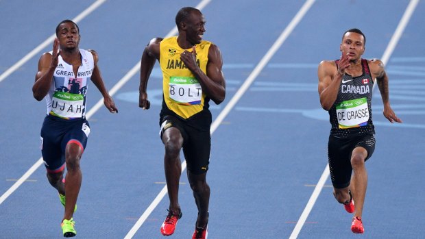 Usain Bolt smiles as he looks at Canada's Andre De Grasse during the semifinal.