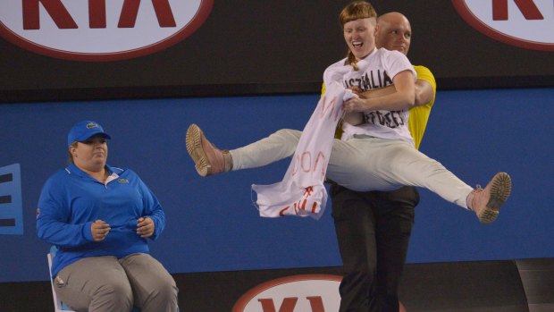 A protester is removed from centre court.