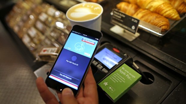 A customer uses an iPhone to pay via Apple Pay in London.