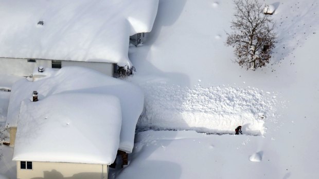 Escape route: A man digs out his driveway in Depew, New York, after the Buffalo area was buried in snow.