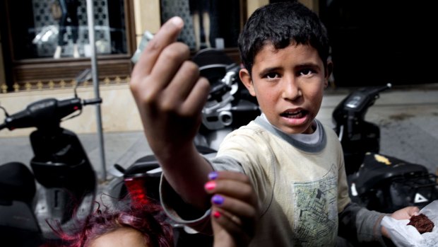 Syrian refugee Mohammad Hussein, 13, right, begs for money on a street in Beirut in March. 