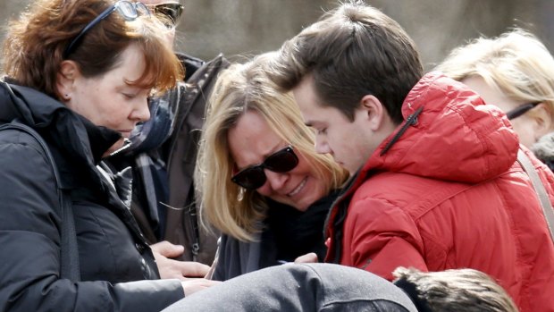 Family members of the pilot of the Germanwings Airbus A320 react as they pay their respects at the memorial for the victims, in the village of Le Vernet, France.
